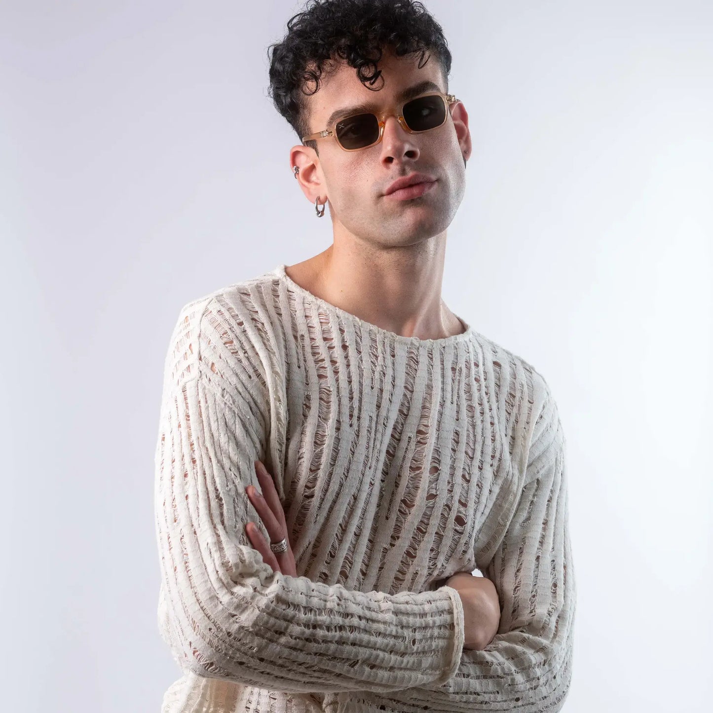 A male model wearing Exposure Sunglasses polarized sunglasses with beige frames and green lenses, posing against a white background.