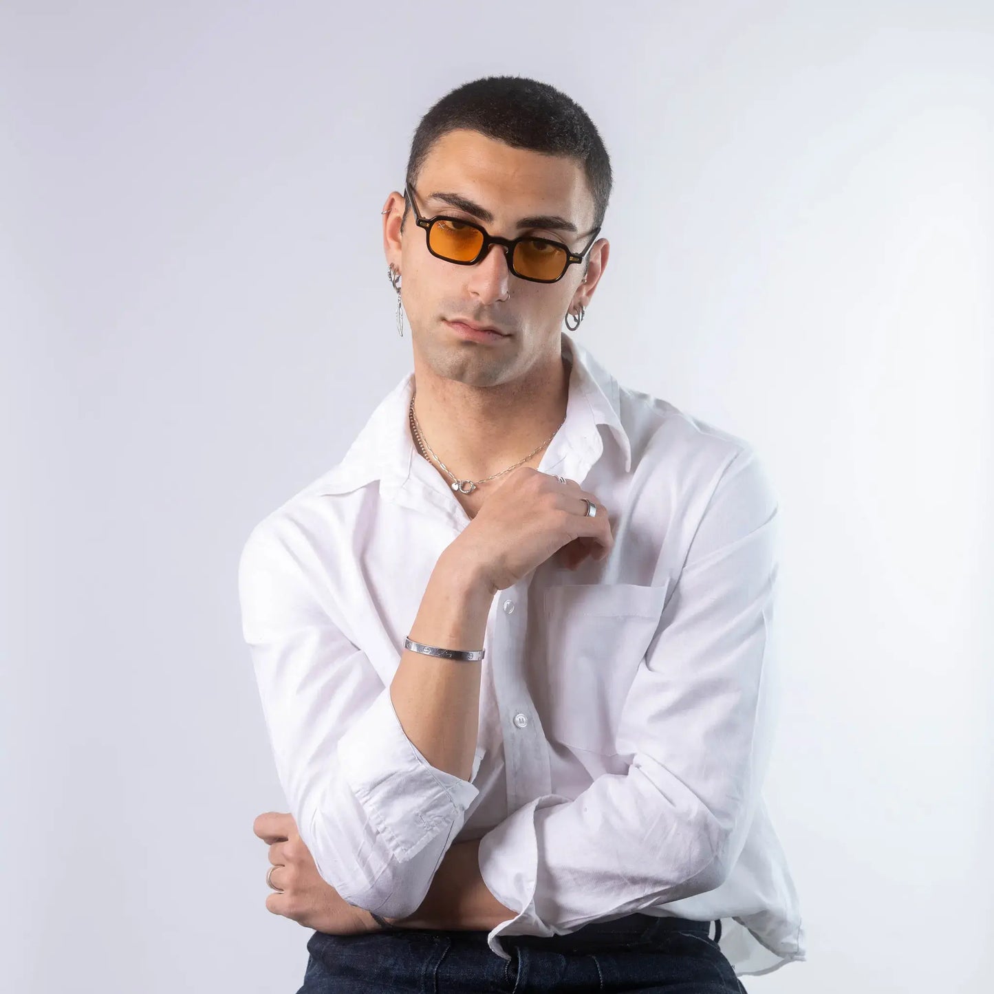 A male model wearing Exposure Sunglasses polarized sunglasses with black frames and orange lenses, posing against a white background.