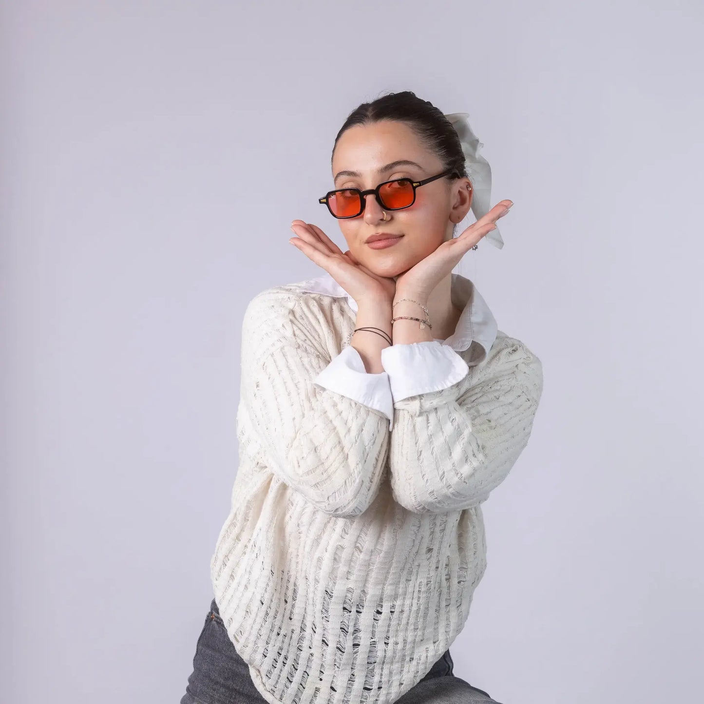 A female model wearing Exposure Sunglasses polarized sunglasses with black frames and red lenses, posing against a white background.
