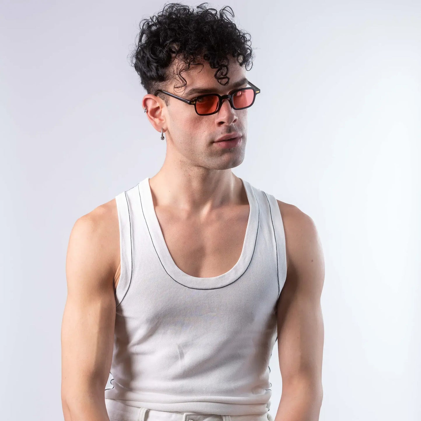 A male model wearing Exposure Sunglasses polarized sunglasses with black frames and red lenses, posing against a white background.