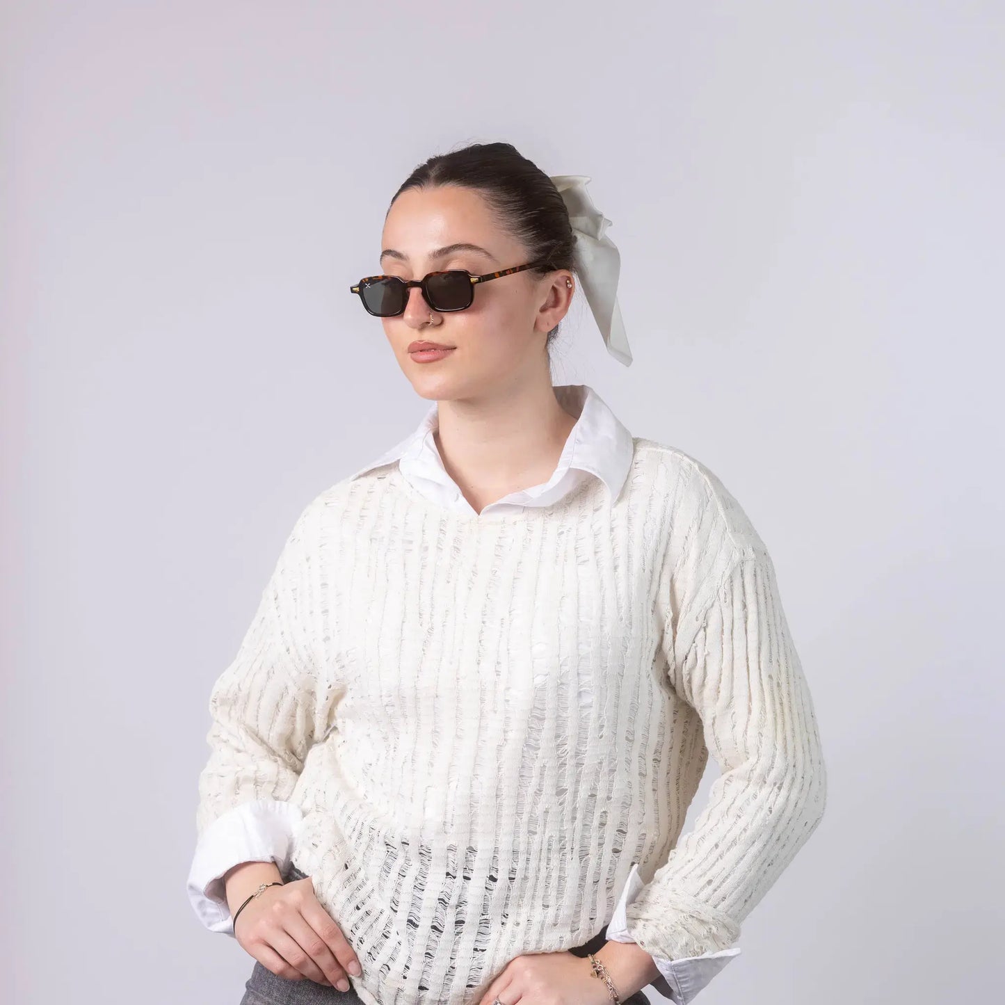 A female model wearing Exposure Sunglasses polarized sunglasses with brown frames and green lenses, posing against a white background.