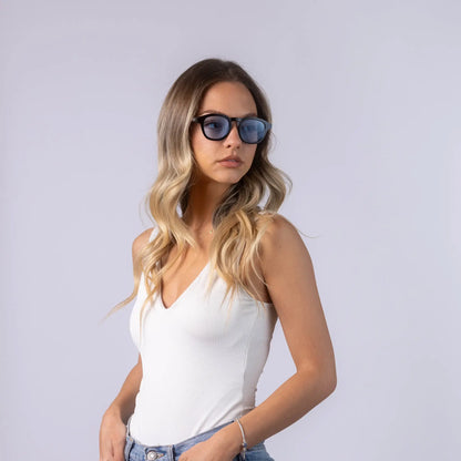Γυαλιά ηλίου Montreal της Exposure Sunglasses με προστασία UV400 με μαύρο σκελετό και μπλε φακό. Φορεμένα από μοντέλο.
