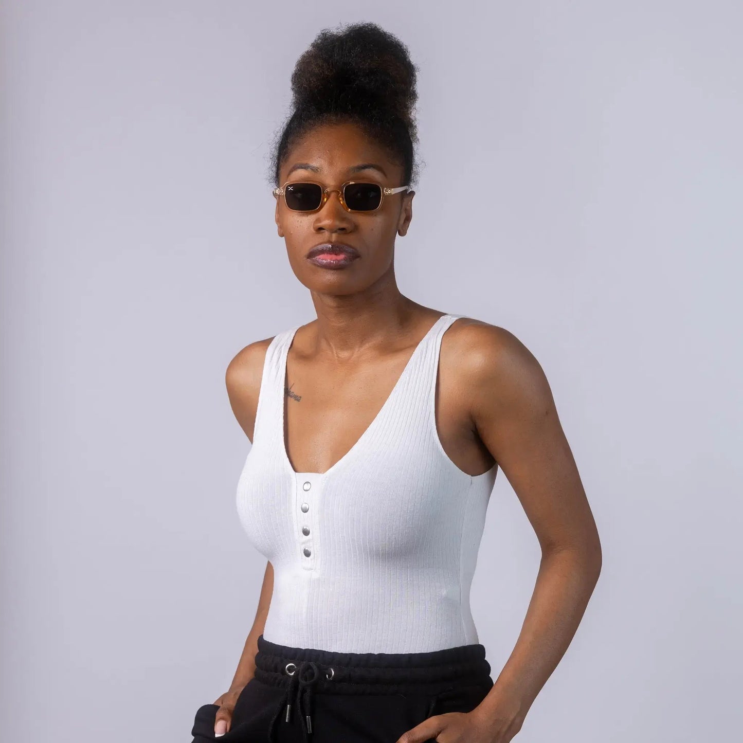 A female model wearing Exposure Sunglasses polarized sunglasses with beige frames and tinted lenses, posing against a white background.